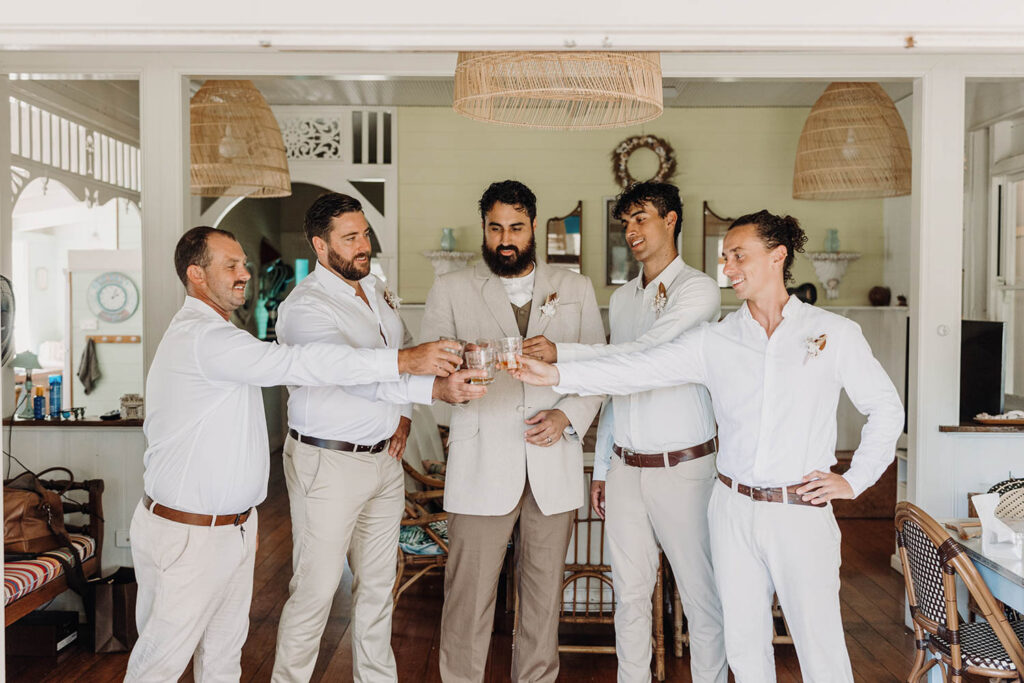 Groomsmen cheering and having a drink before the wedding